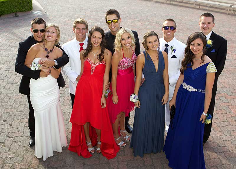 Five young couples dressed up for prom